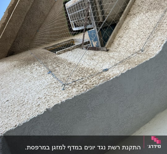 רשת מתוחה על קיר למניעת כניסת יונים